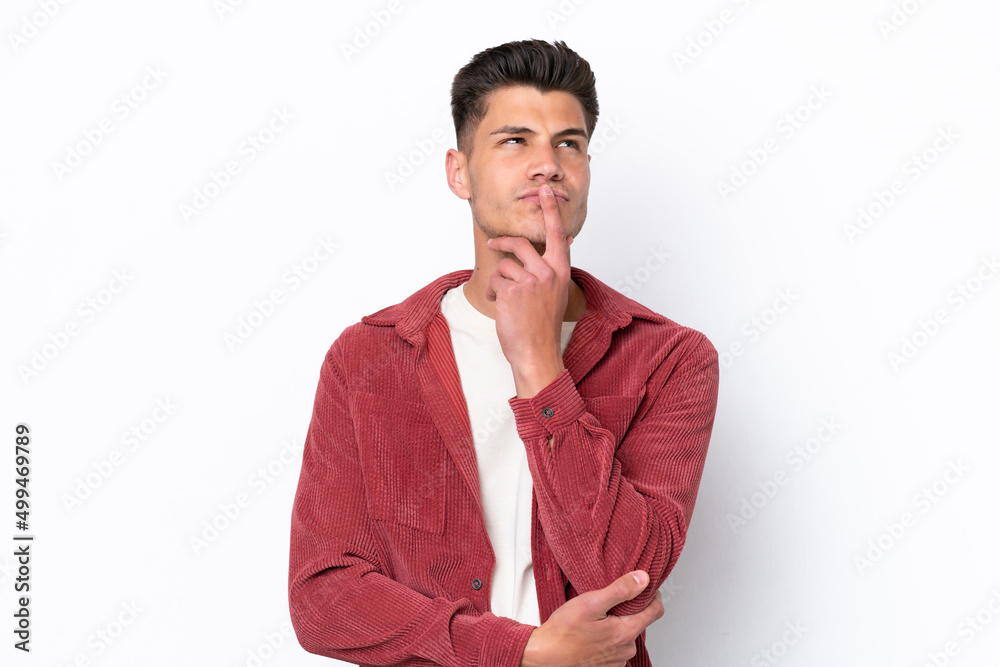 Young caucasian man isolated on white background having doubts while looking up Young caucasian man isolated on white background having doubts while looking up