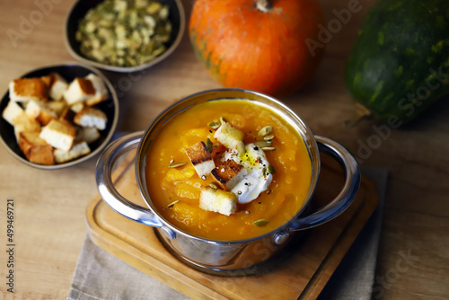 Pumpkin soup in a saucepan with croutons.