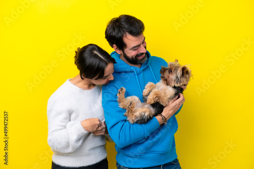 Young caucasian couple holding a dog
