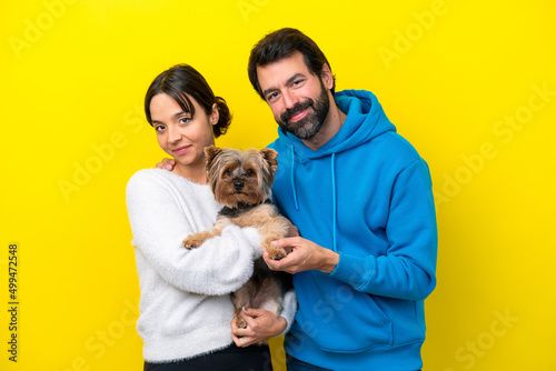 Young caucasian couple holding a dog © luismolinero