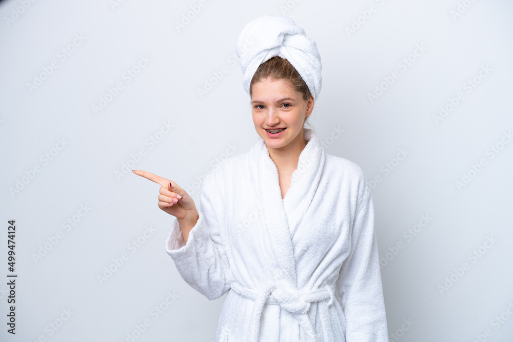 Teenager Russian girl in a bathrobe isolated on white background pointing finger to the side Teenager Russian girl in a bathrobe isolated on white background pointing finger to the side