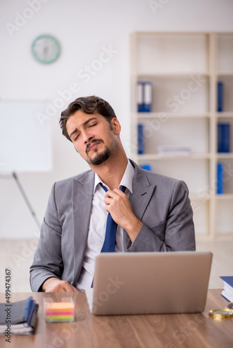 Young male employee sitting in the office