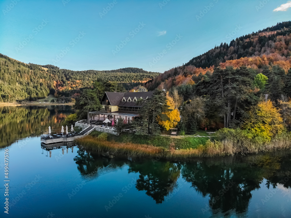 Colorful autumn landscape view wooden Lake house in autumn forest with a pond
