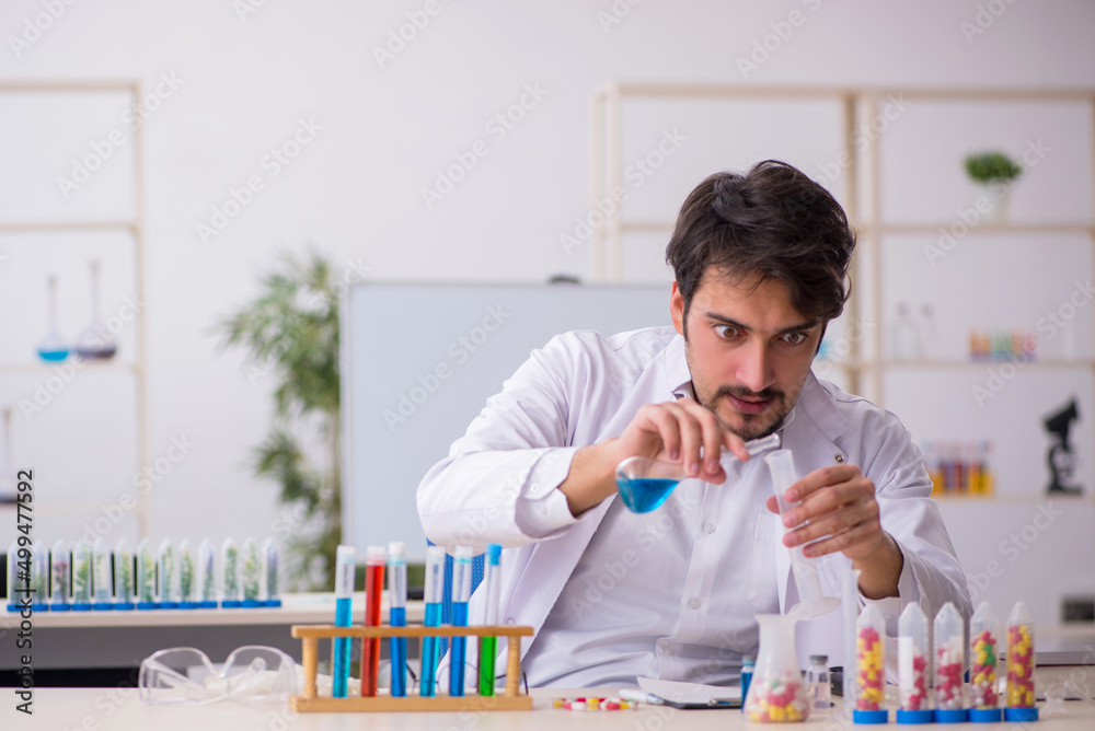 Young male chemist in drugs synthesis concept Young male chemist in drugs synthesis concept