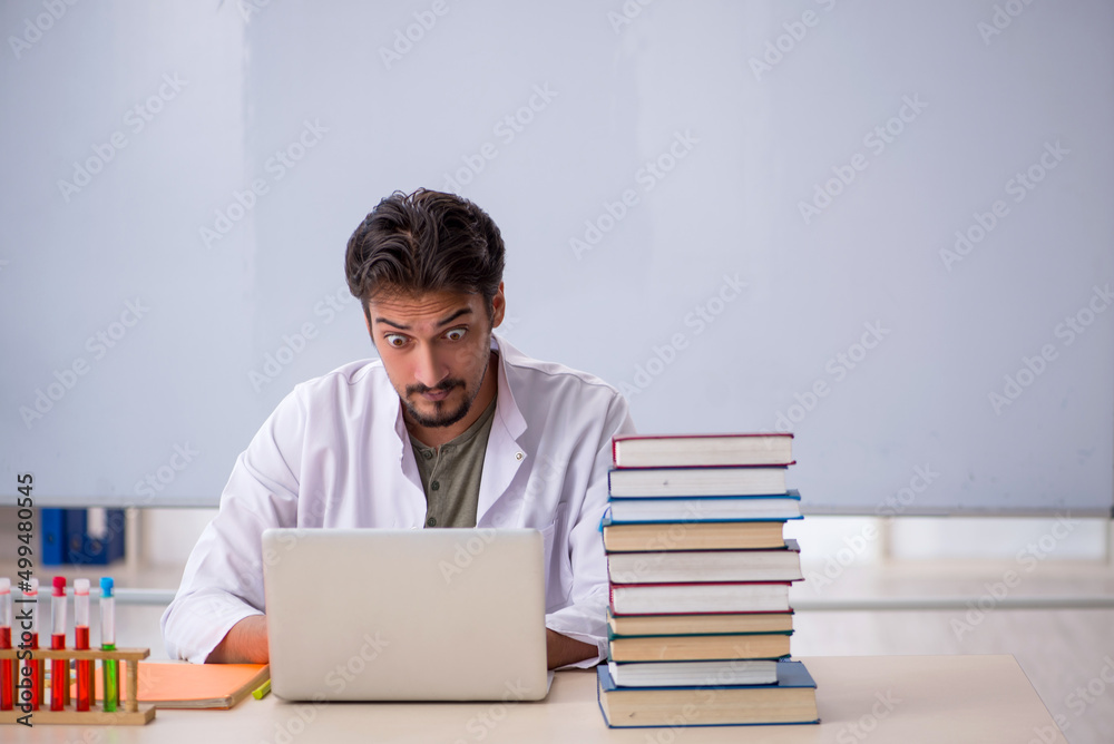 Young male chemist teacher in front of whiteboard Young male chemist teacher in front of whiteboard