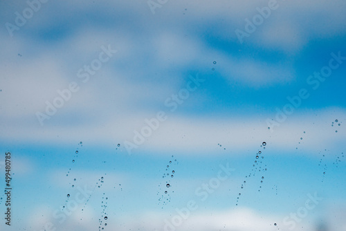 Raindrops on a window against the sky © Ruben Chase