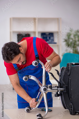 Young male repairman working at workshop