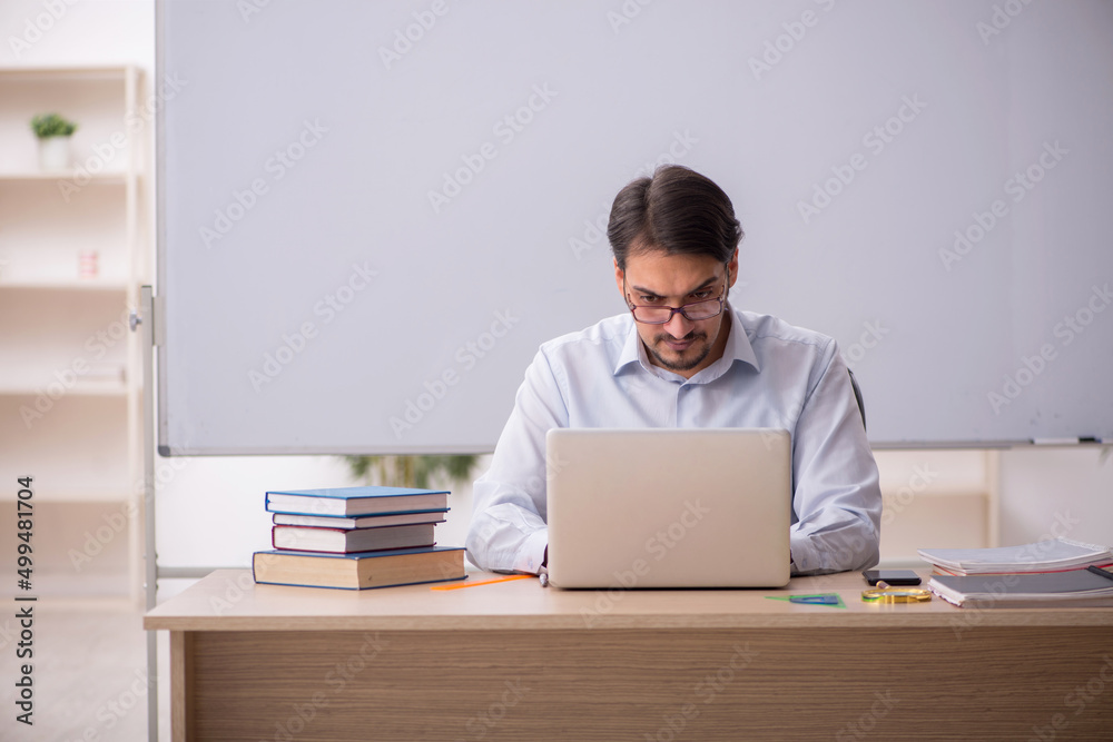 Young male teacher in front of whiteboard Young male teacher in front of whiteboard