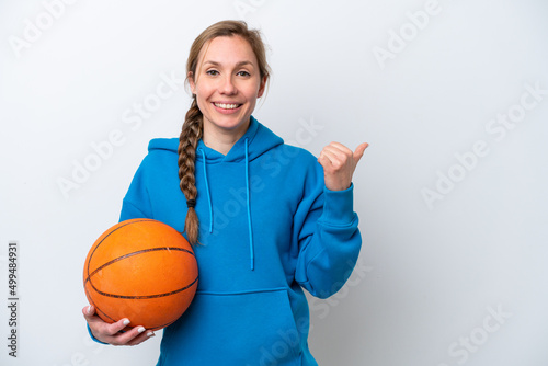 Young caucasian woman playing basketball isolated on white background pointing to the side to present a product © luismolinero