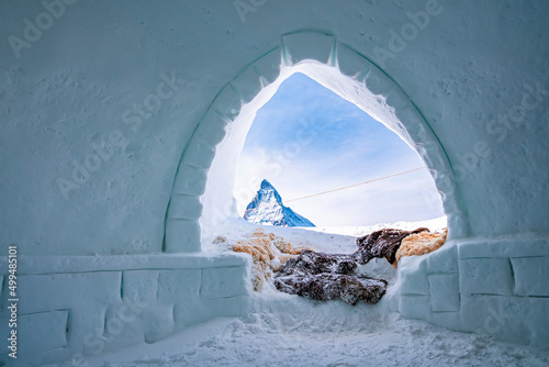 Snowcapped Matterhorn peak against sky seen through entrance of igloo in alps