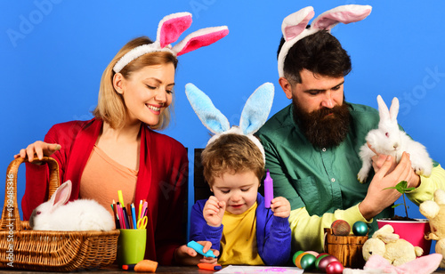 Easter family traditions. Happy mother, father and little son in bunny ears preparing for holidays.