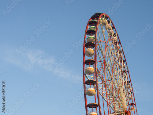 Ferris wheel against the sky. Amusement park on the sea. Rest zone.
