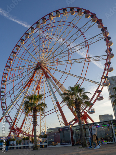 Ferris wheel against the sky. Amusement park on the sea. Rest zone. Ferris wheel. Family holiday