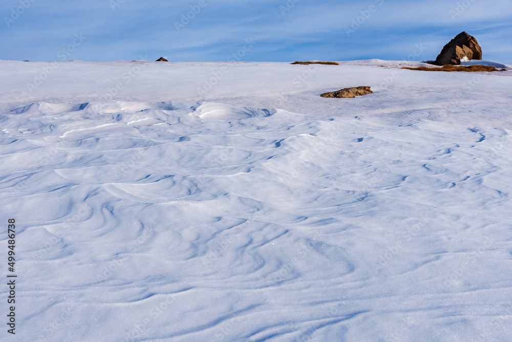 Snow eroded by the action of the wind, also called Sastrugi, on a hill in the peaks of the Sierra Nevada.