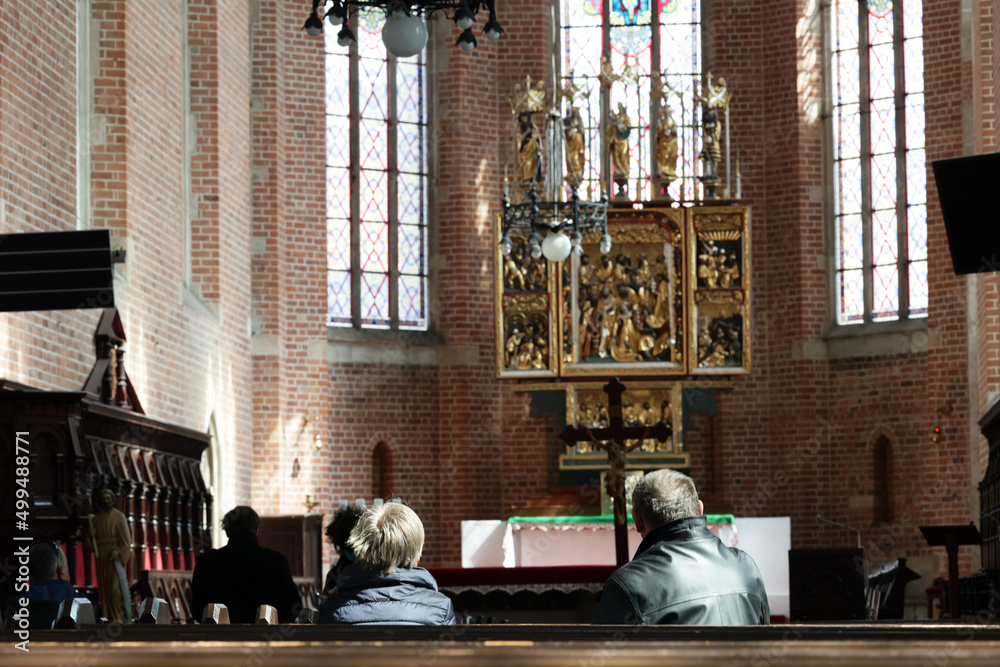 Para ludzi modli się w świętym kościele w skupieniu podczas świąt - obrazy, fototapety, plakaty 