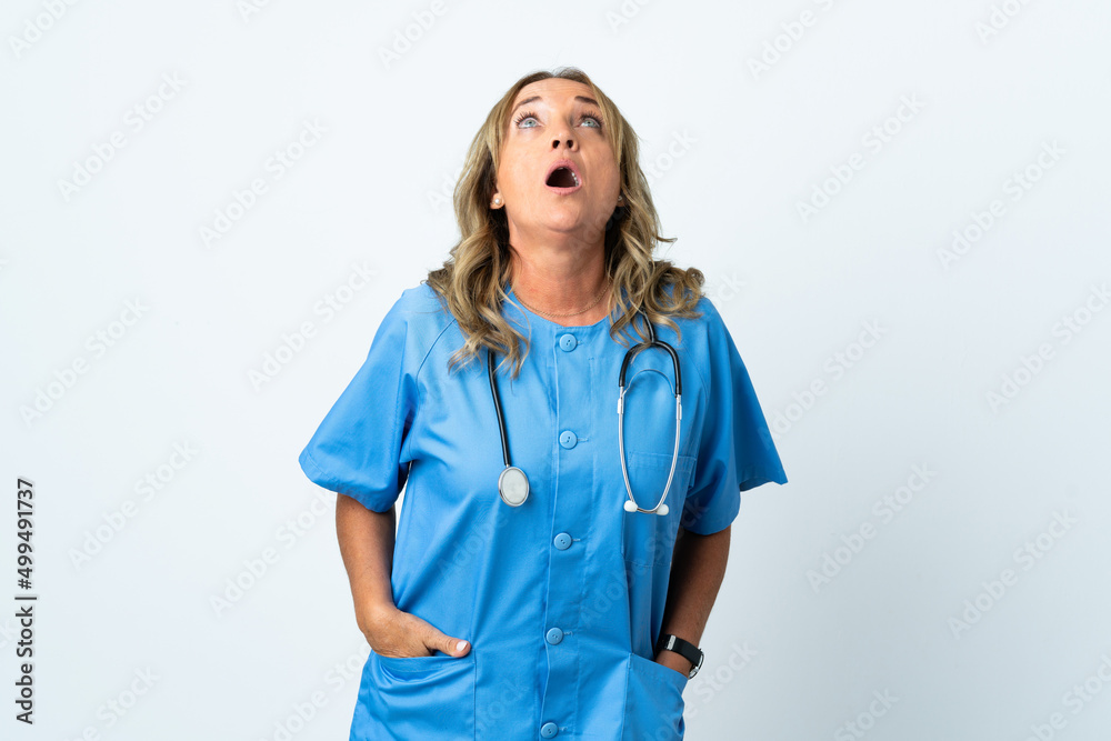 Middle aged surgeon woman over isolated background looking up and with surprised expression Middle aged surgeon woman over isolated background looking up and with surprised expression