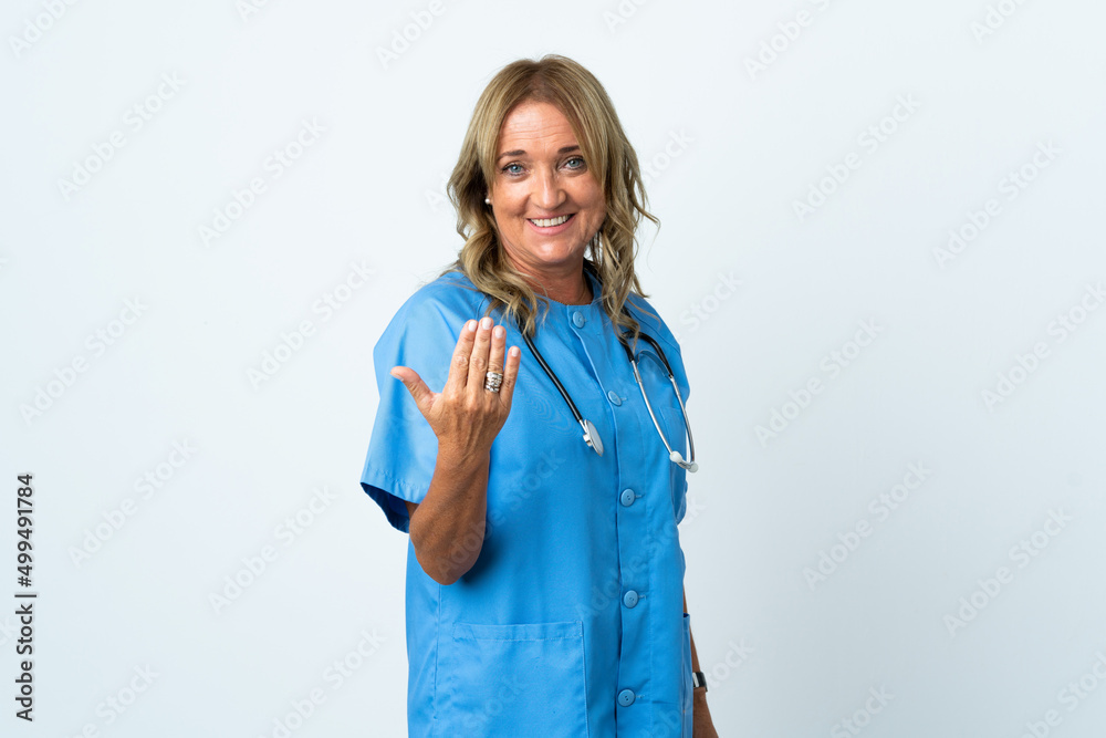 Middle aged surgeon woman over isolated background inviting to come with hand. Happy that you came Middle aged surgeon woman over isolated background inviting to come with hand. Happy that you came