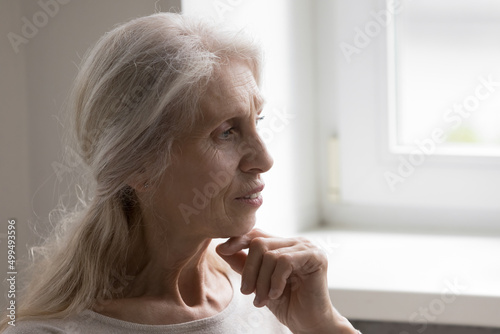 Obraz na plátně Close up profile face view pensive calm mature gray haired woman put chin on han