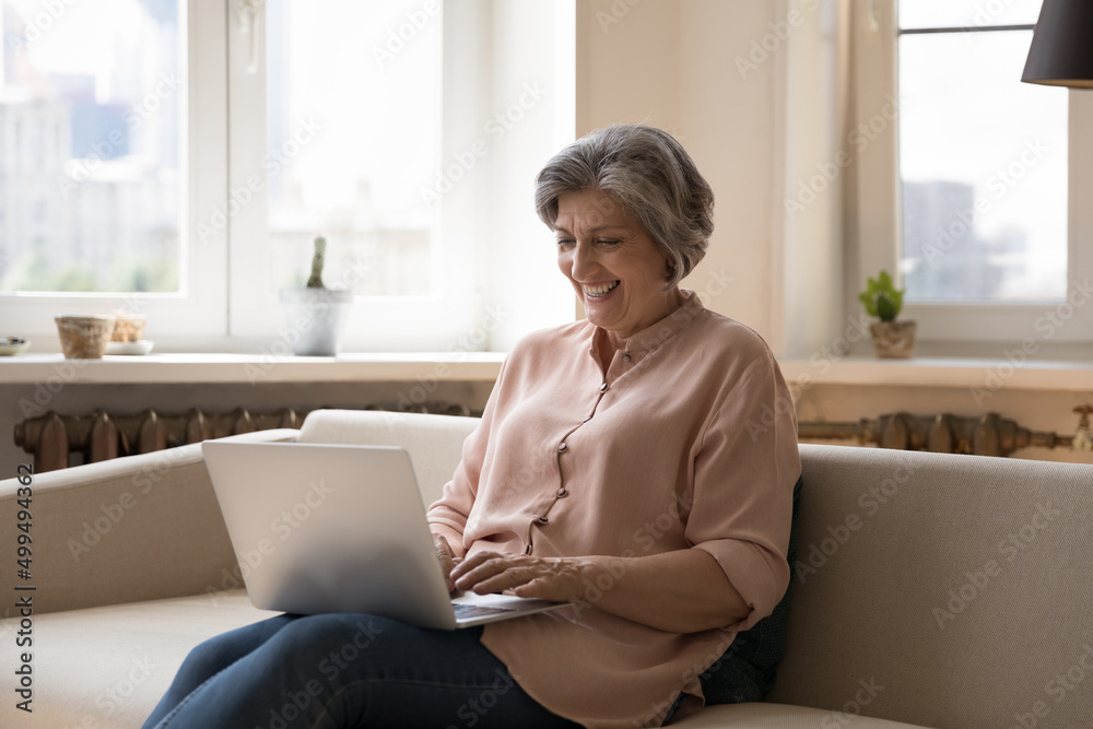 Happy overjoyed middle aged woman enjoy chat share text messages in social media, have fun on internet spend time use laptop. Older gen use modern tech, satisfied client of electronic services concept Happy overjoyed middle aged woman enjoy chat share text messages in social media, have fun on internet spend time use laptop. Older gen use modern tech, satisfied client of electronic services concept