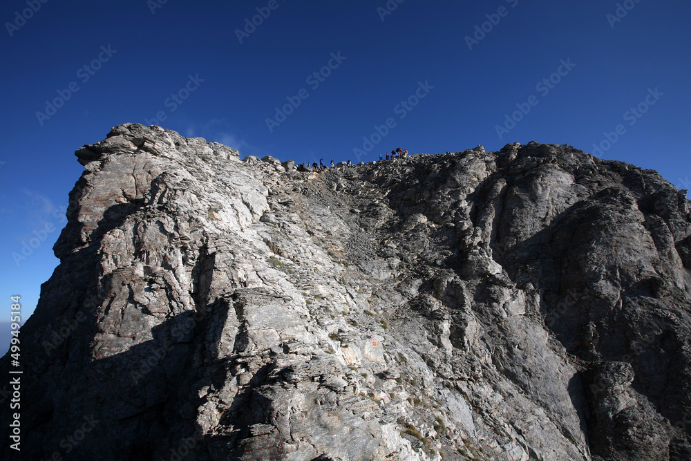 View of Mount Olympus peak Mytikas. Mount Olympus is highest mountain in Greece at 2917 meters. Mount Olympus is the home of the Twelve Olympians, the principal gods in the Greek pantheon. View of Mount Olympus peak Mytikas. Mount Olympus is highest mountain in Greece at 2917 meters. Mount Olympus is the home of the Twelve Olympians, the principal gods in the Greek pantheon.