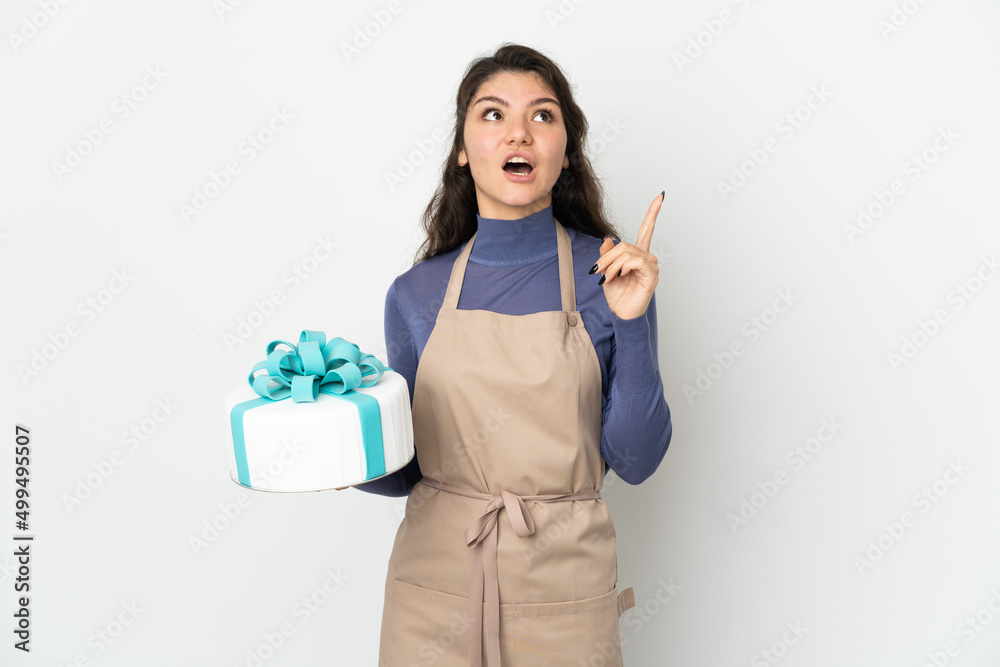 Pastry Russian chef holding a big cake isolated on white background intending to realizes the solution while lifting a finger up Pastry Russian chef holding a big cake isolated on white background intending to realizes the solution while lifting a finger up