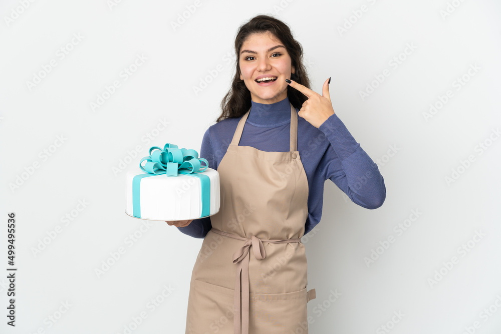 Pastry Russian chef holding a big cake isolated on white background giving a thumbs up gesture Pastry Russian chef holding a big cake isolated on white background giving a thumbs up gesture