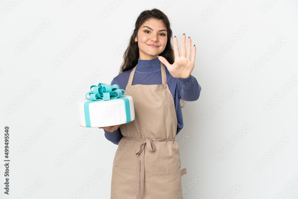 Pastry Russian chef holding a big cake isolated on white background counting five with fingers Pastry Russian chef holding a big cake isolated on white background counting five with fingers