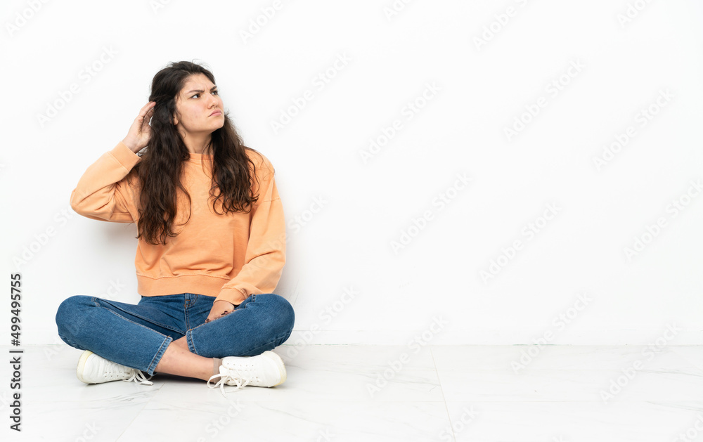 Teenager Russian girl sitting on the floor having doubts Teenager Russian girl sitting on the floor having doubts