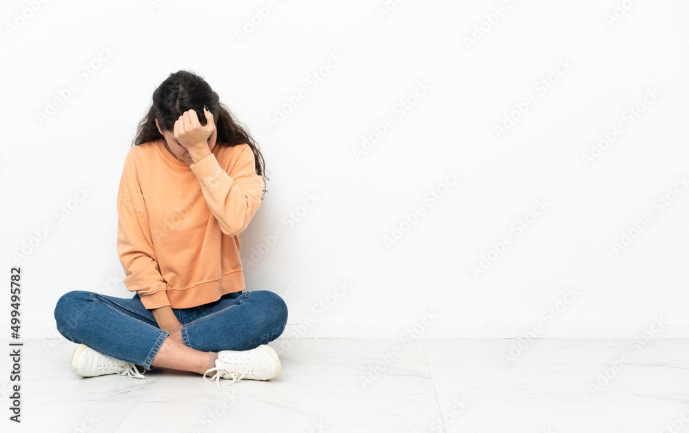 Teenager Russian girl sitting on the floor with headache Teenager Russian girl sitting on the floor with headache