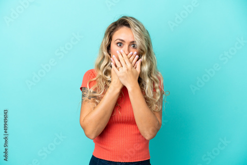 Young Brazilian woman isolated on blue background covering mouth with hands