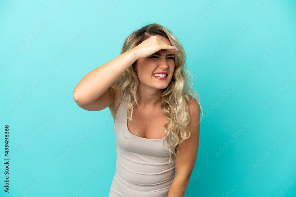 Young Brazilian woman isolated on blue background looking far away with hand to look something