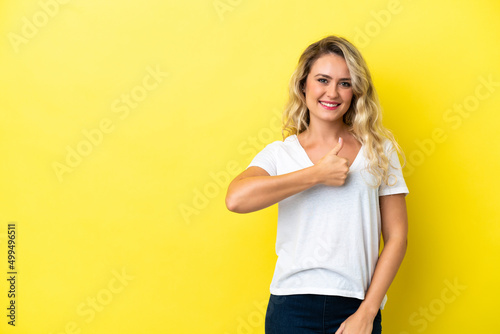 Young Brazilian woman isolated on yellow background giving a thumbs up gesture