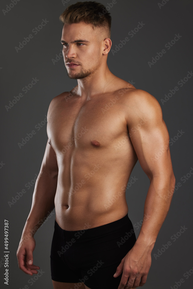 Focused on his fitness goals. Cropped shot of a handsome and athletic young man posing shirtless in studio against a dark background.