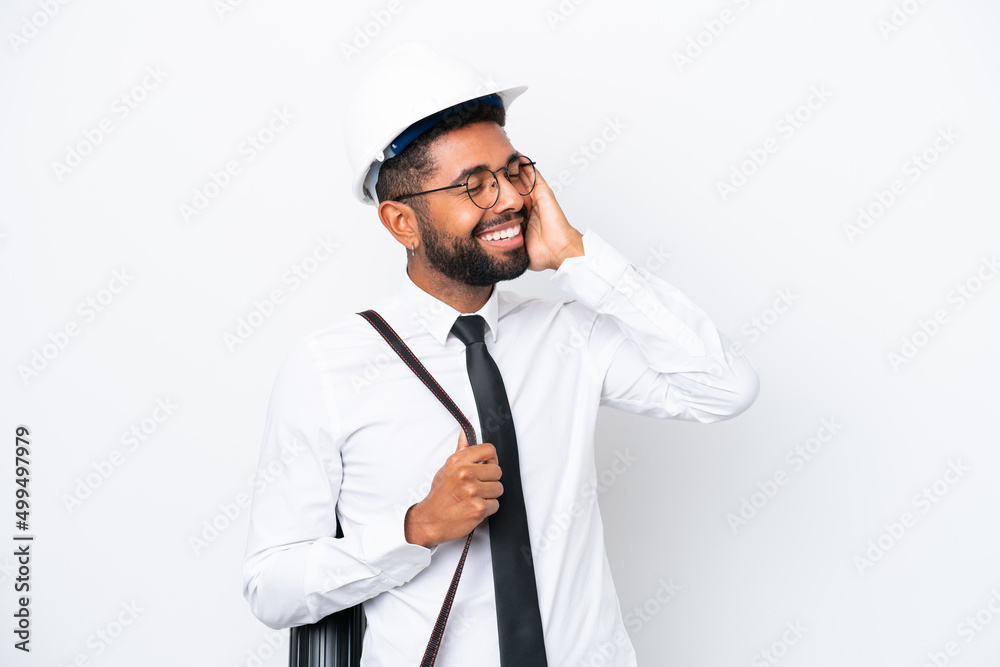 Young architect Brazilian man with helmet and holding blueprints isolated on white background smiling a lot