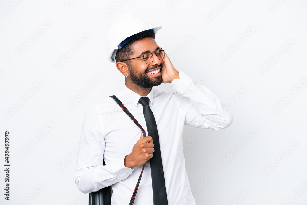 Young architect Brazilian man with helmet and holding blueprints isolated on white background smiling a lot Young architect Brazilian man with helmet and holding blueprints isolated on white background smiling a lot