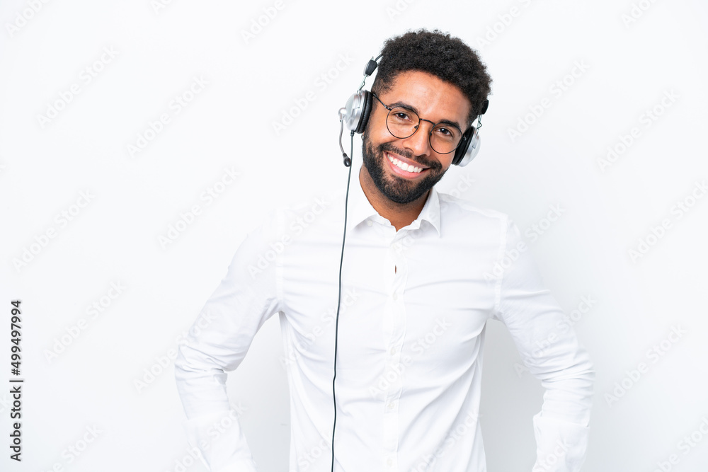 Telemarketer Brazilian man working with a headset isolated on white background posing with arms at hip and smiling Telemarketer Brazilian man working with a headset isolated on white background posing with arms at hip and smiling