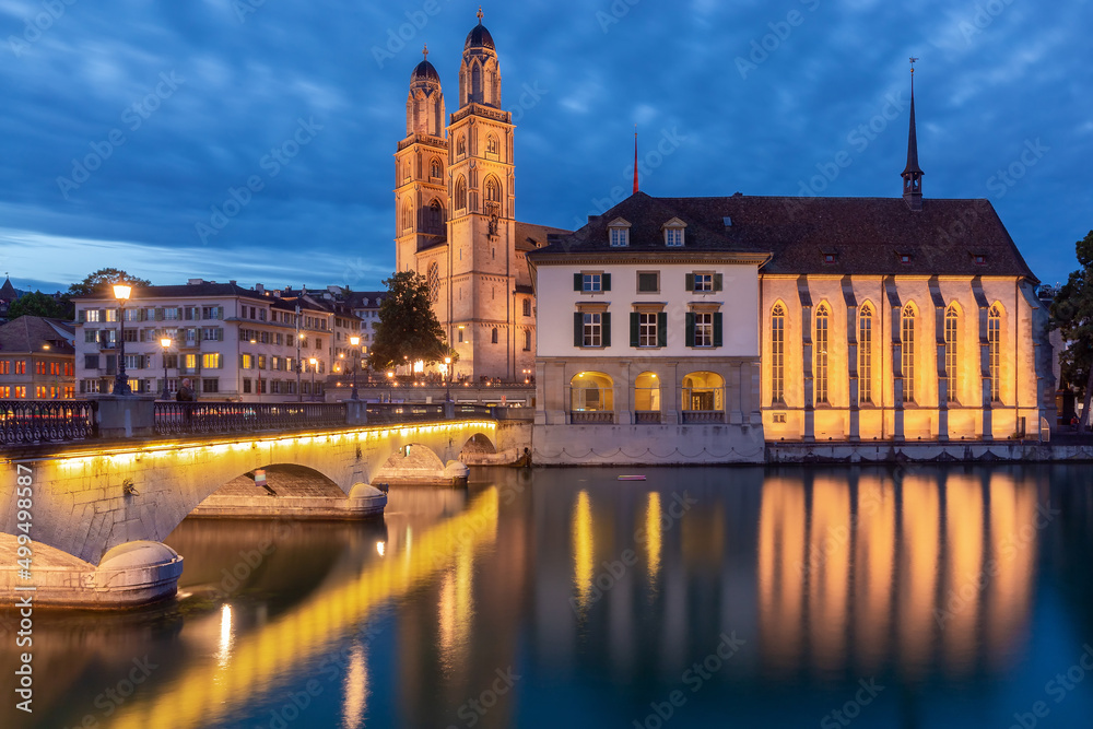 Zurich. View of the city embankment and the church Grossmunster at sunset.