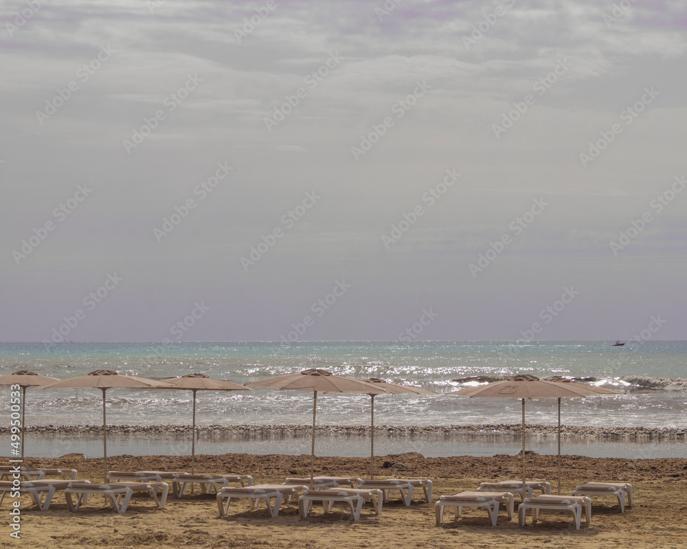 umbrellas and sunbeds on the beach at the Mediterranean Sea umbrellas and sunbeds on the beach at the Mediterranean Sea