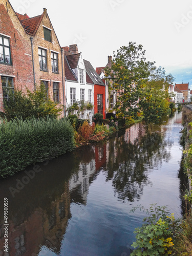 The historical city center of Bruges with medieval brick houses along a canal 