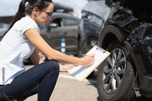 Insurance agent records damage to car after accident