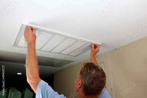 Tablou pe pânză Adult Fingers Placed on White Air Intake Vent Grid Open Latches.