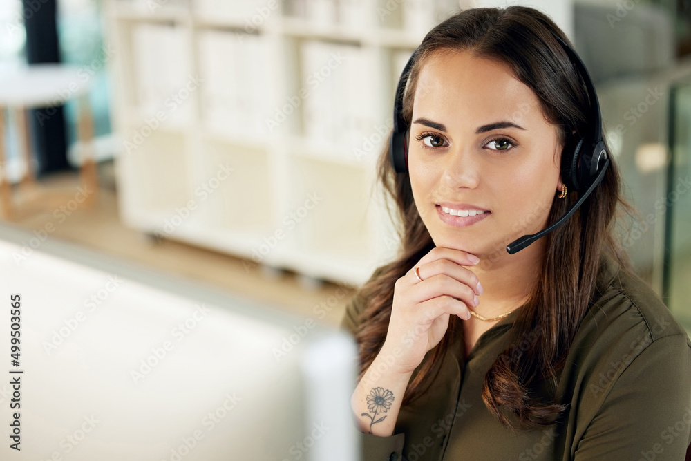 With customer care comes customer loyalty. Portrait of a young businesswoman using a headset and computer in a modern office. With customer care comes customer loyalty. Portrait of a young businesswoman using a headset and computer in a modern office.