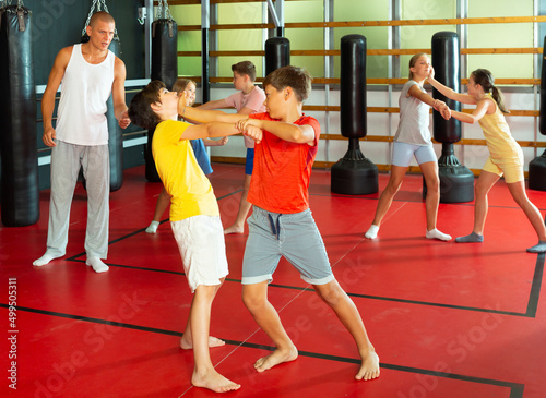 Kids in pairs training chin strike during their self-protection training.