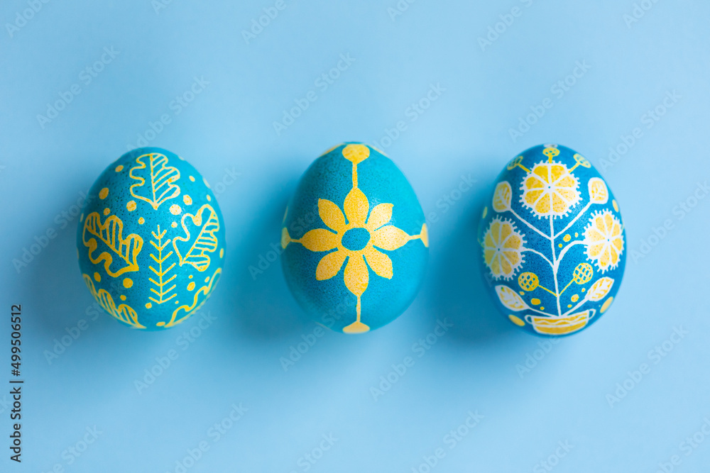 Macro view of Easter eggs painted with Ukrainian national colors, blue and yellow, and depicting Ukrainian ornaments