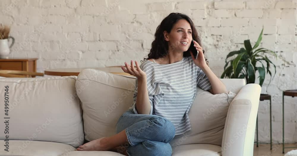 Chatterbox. Pretty millennial Hispanic woman relax on soft comfy couch on weekend alone hold cellphone chat to friend laugh tell hilarious story. Energetic positive young lady talk on phone having fun Chatterbox. Pretty millennial Hispanic woman relax on soft comfy couch on weekend alone hold cellphone chat to friend laugh tell hilarious story. Energetic positive young lady talk on phone having fun