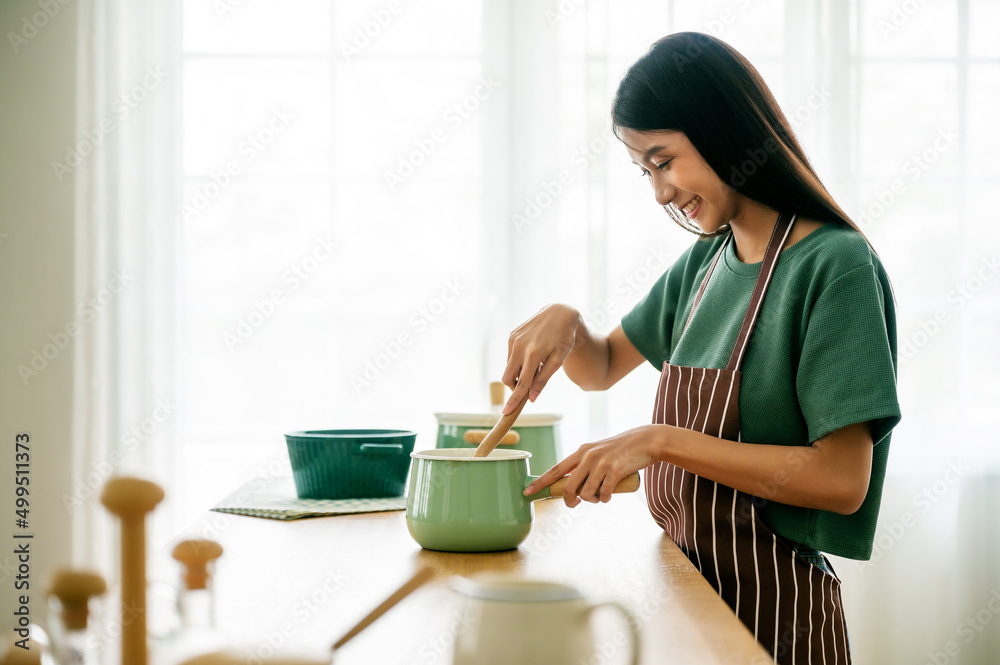 Young beauty asian woman cooking in kitchen room at home Young beauty asian woman cooking in kitchen room at home
