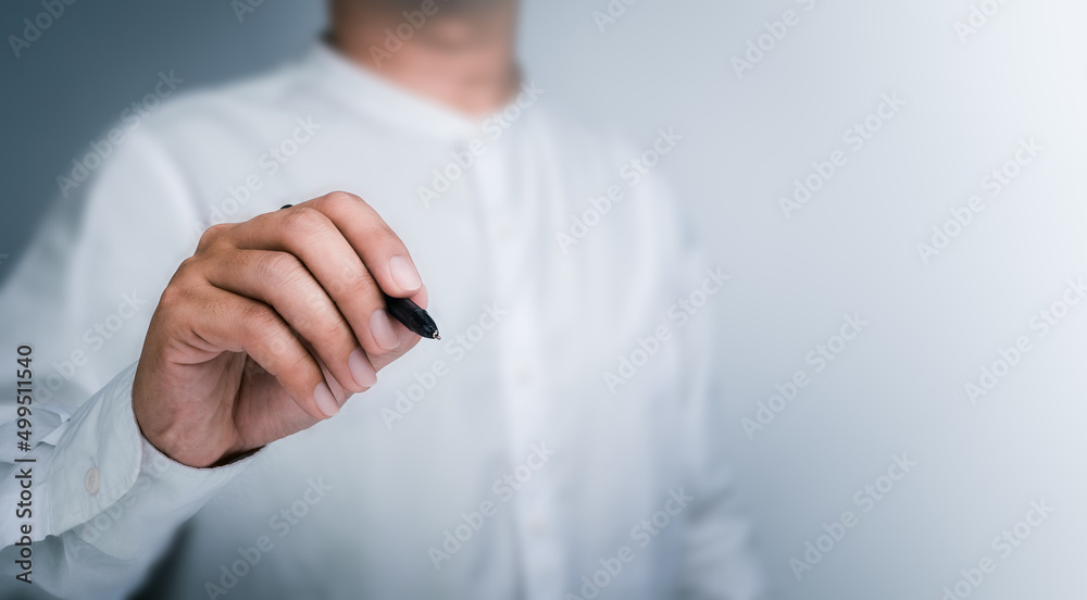 Black pen in businessman's hand while drawing with empty on white background with copy space. A man, a person writes something on a virtual screen. Black pen in businessman's hand while drawing with empty on white background with copy space. A man, a person writes something on a virtual screen.