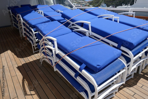 Принти на полотні Lounge chairs with blue cushions stacked up on cruise ship wooden deck