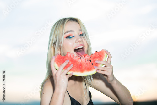 Closeup portrait of young blonde sensual woman eating watermelon. Tropical vacation travel sexy girl concept. photo