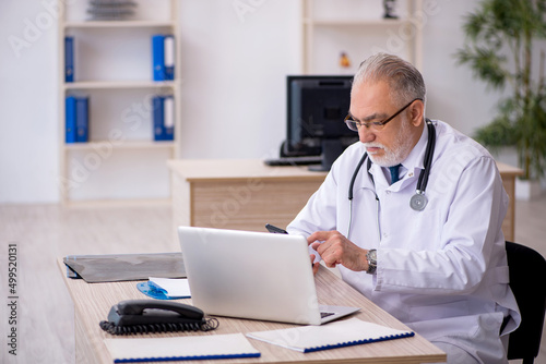 Old male doctor in telemedicine concept